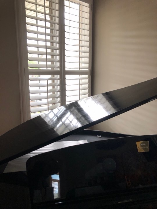White shutters above a grand piano