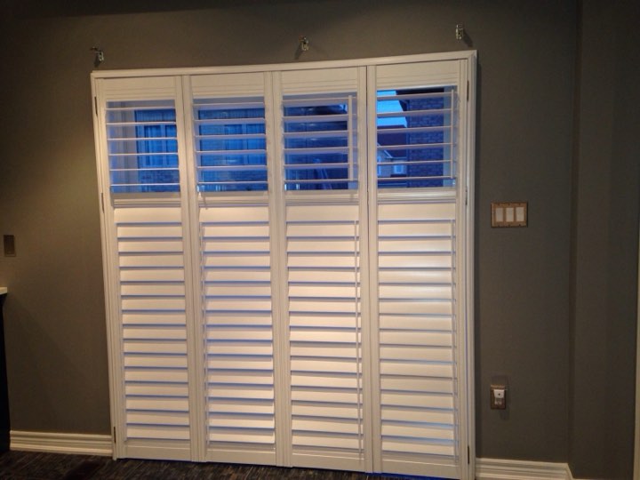 Four-panel white shutters with the top louvres open