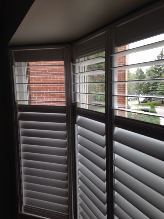 White shutters around a corner bay window